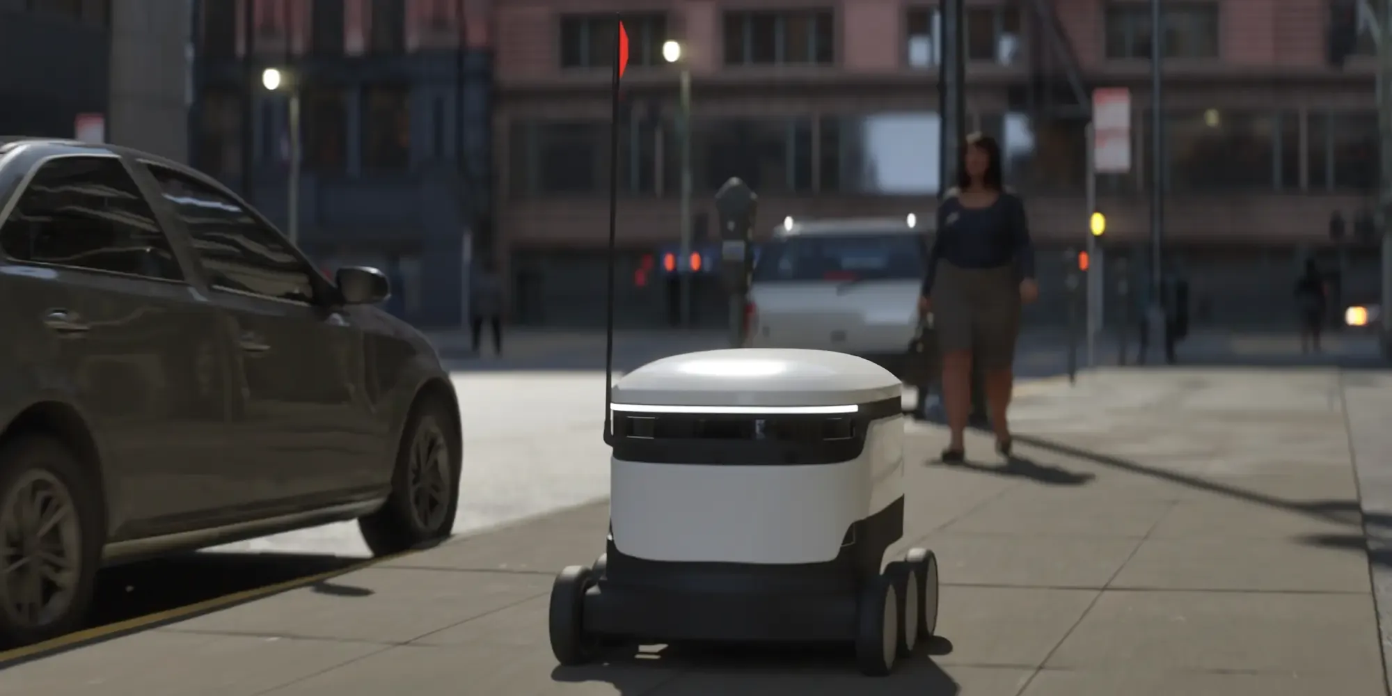 A white, four-wheeled autonomous delivery robot with a tall red flag navigates down a city sidewalk, passing a parked car while a pedestrian walks in the blurred background.