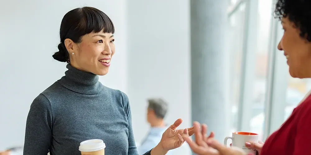 A smiling TaskUs employee in a wheelchair, appearing engaged in his workplace, hinting the vibrant work culture and employee benefits of TaskUs
