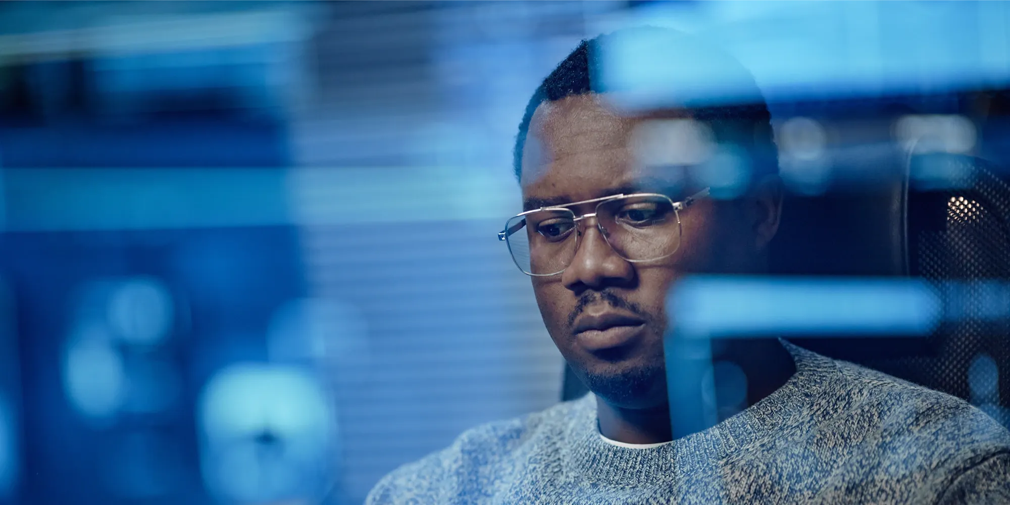 Focused content moderation specialist reviewing digital data on a screen in a high-tech cybersecurity office.