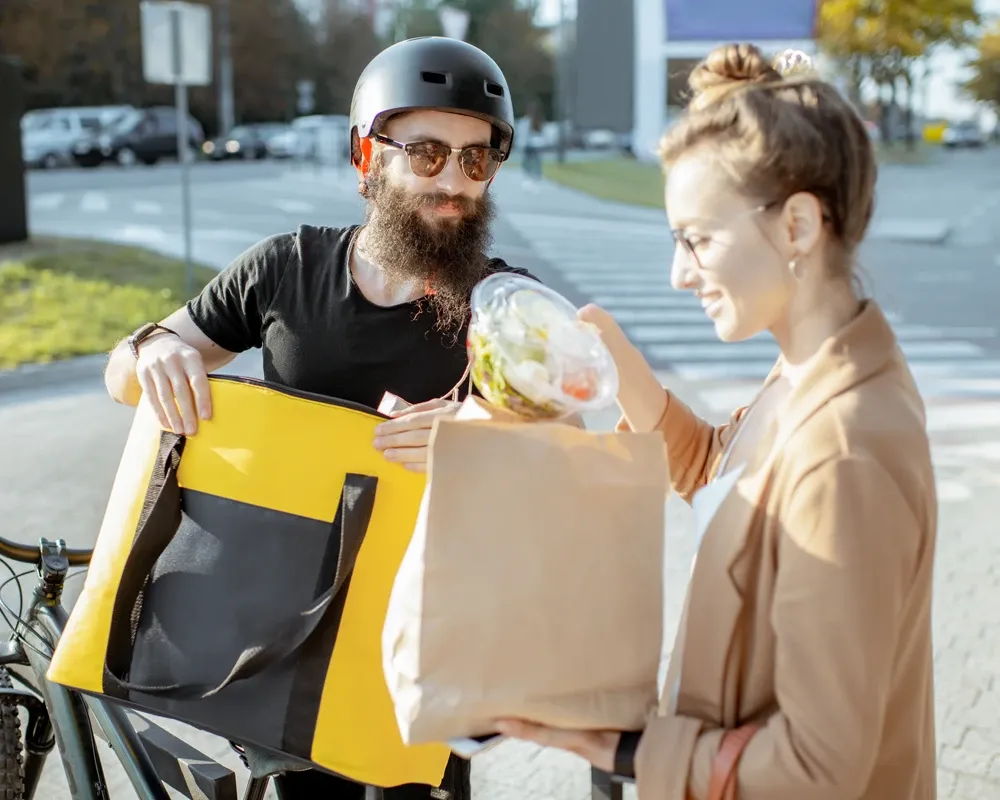 A satisfied food delivery app customer, supported by TaskUs' digital