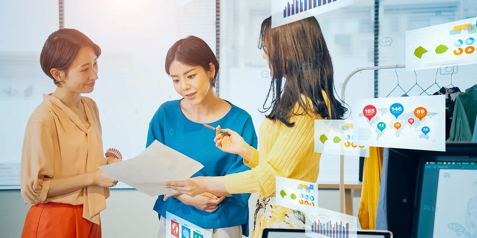 hree women in a modern workspace review documents surrounded by floating digital data overlays, charts, and global metrics.