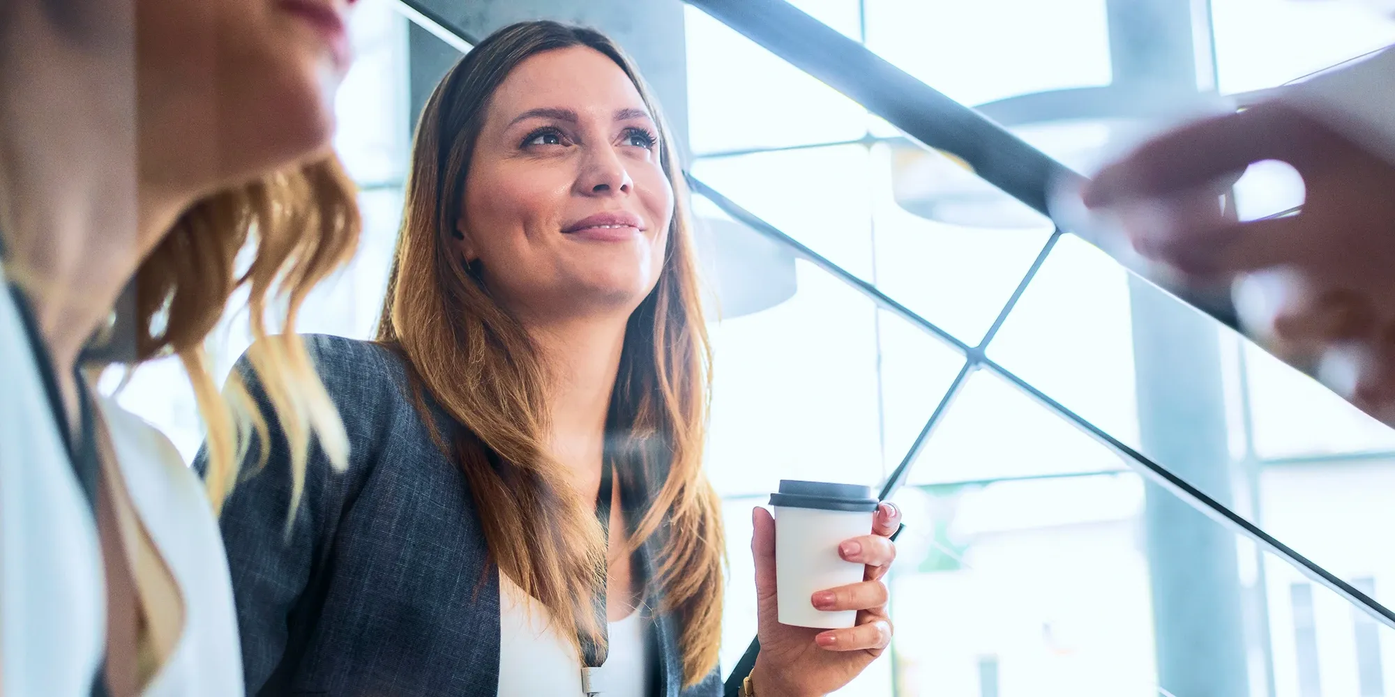 TaskUs teammate engaging in a discussion in a bright, open-plan workspace.
